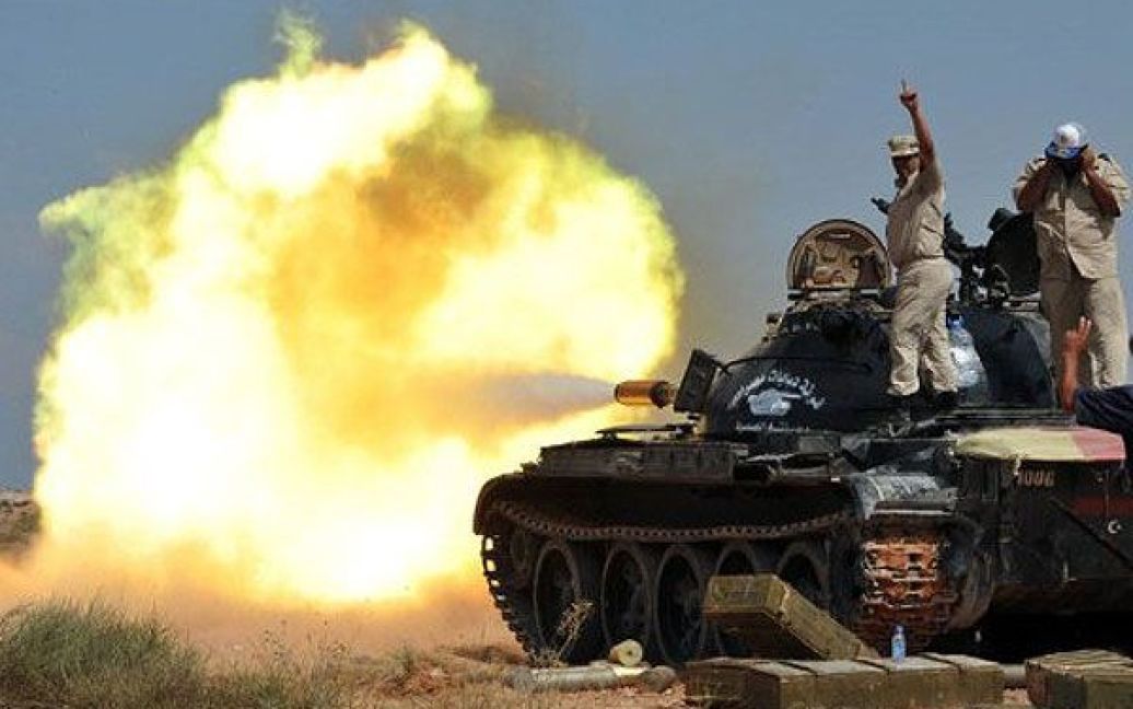 Лівійська Арабська Джамахірія, Сірт. Бійці прехідної національної ради Лівії (ПНР) стріляють з танка по військам, вірним Муаммару Каддафі, які утримують місто Сірт. / © AFP