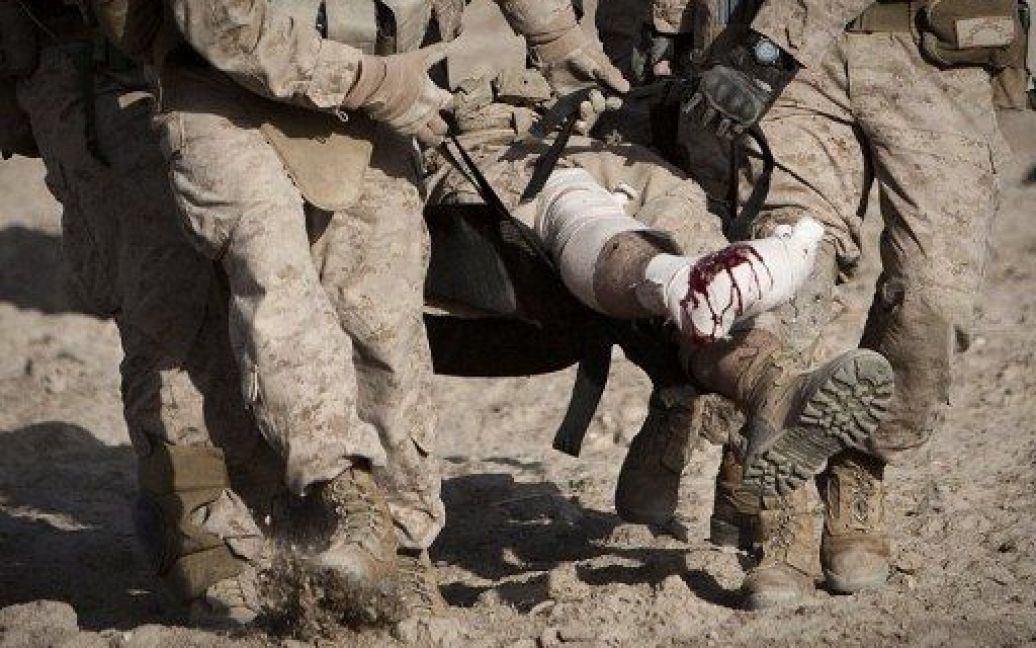 Афганістан, Гільменд. Солдата, який отримав поранення від саморобного вибухового пристрою, переносять до санітарного вертольоту його товариші з авіаційного полку в провінції Гільменд. / © AFP