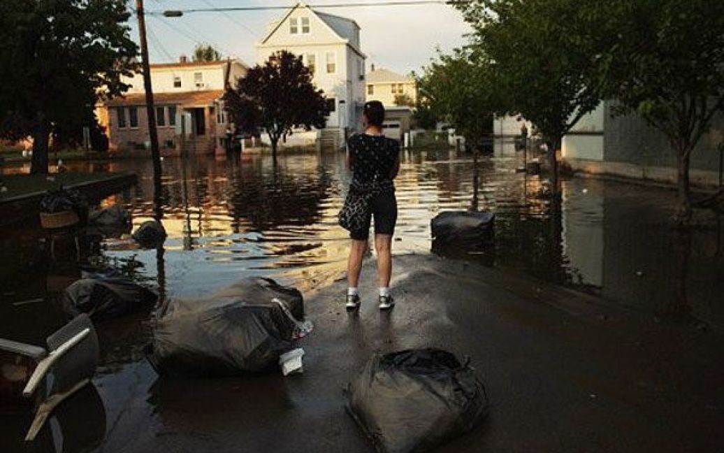 США, Уоллінгтон, штат Нью-Джерсі. Жінка стоїть на затопленій вулиці у Уоллінгтоні. Штат Нью-Джерсі сильно постраждав від урагану "Айрін", тисячі жителів залишили свої затоплені будинки, міста досі лишаються без електрики. річки і струмки переповнені. / © AFP