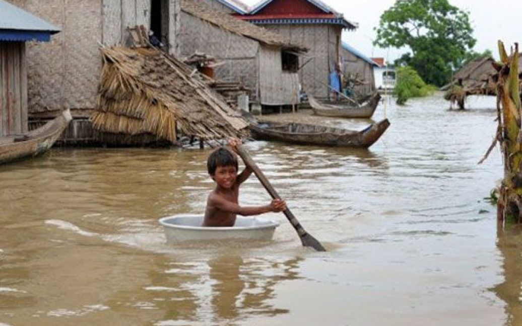Камбоджа, Кандала. Камбоджійський хлопчик пливе у мисці через затоплене село у провінції Кандала поблизу Пномпеня. Більше 100 камбоджійців, майже половина з яких діти, загинули в результаті найсильнішої в країні за останні десять років повені. / © AFP