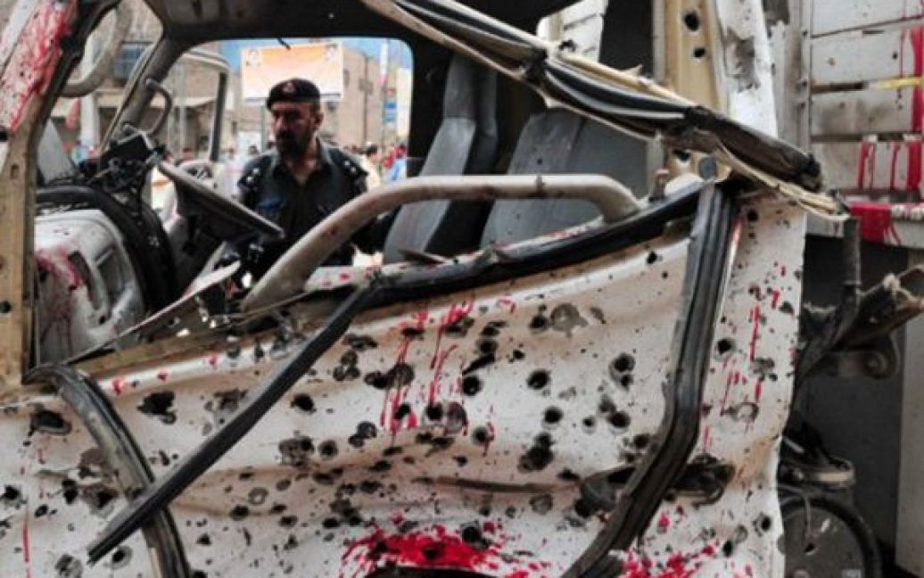 Пакистан, Пешавар. Поліцейський оглядає уламки службового автомобіля, який вибухнув внаслідок теракту. Жінка-терорист підірвала себе біля фургону поліції. В результаті вибуху загинули 6 людей. / © AFP