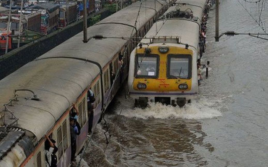 Індія, Мумбаї. Місцеві поїзди проходять через затоплені після важких злив залізничні шляхи в Мумбаї. Транспортне сполучення в країні було порушено в результаті мусонних дощів. / © AFP