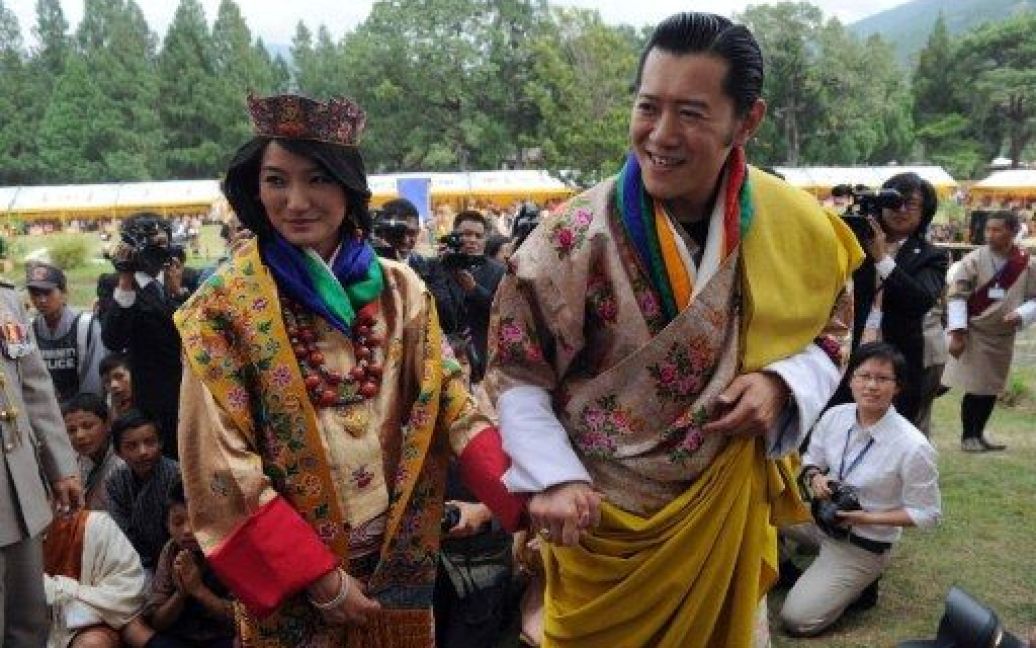 Бутан, Пунакха. Король Бутана Джігме Вангчук Кхесар Намгуель та його молода дружина, нова королева Бутану, Джецун Пема вітають натовп після церемонії одруження в буддистському монастирі Дзонг Пунакха. 31-річний король Бутану одружився на звичайній студентці. / © AFP