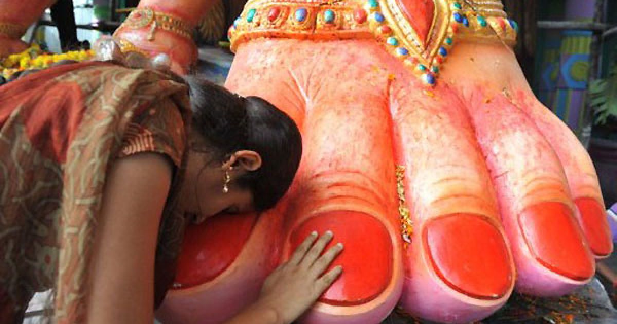 Індія, Хайдарабад. Індійська жінка торкається ноги 52-футової фігури індуїстського бога Ганеша під час святкування фестивалю "Ганеш Чатурті" у Хайдарабаді. / © AFP