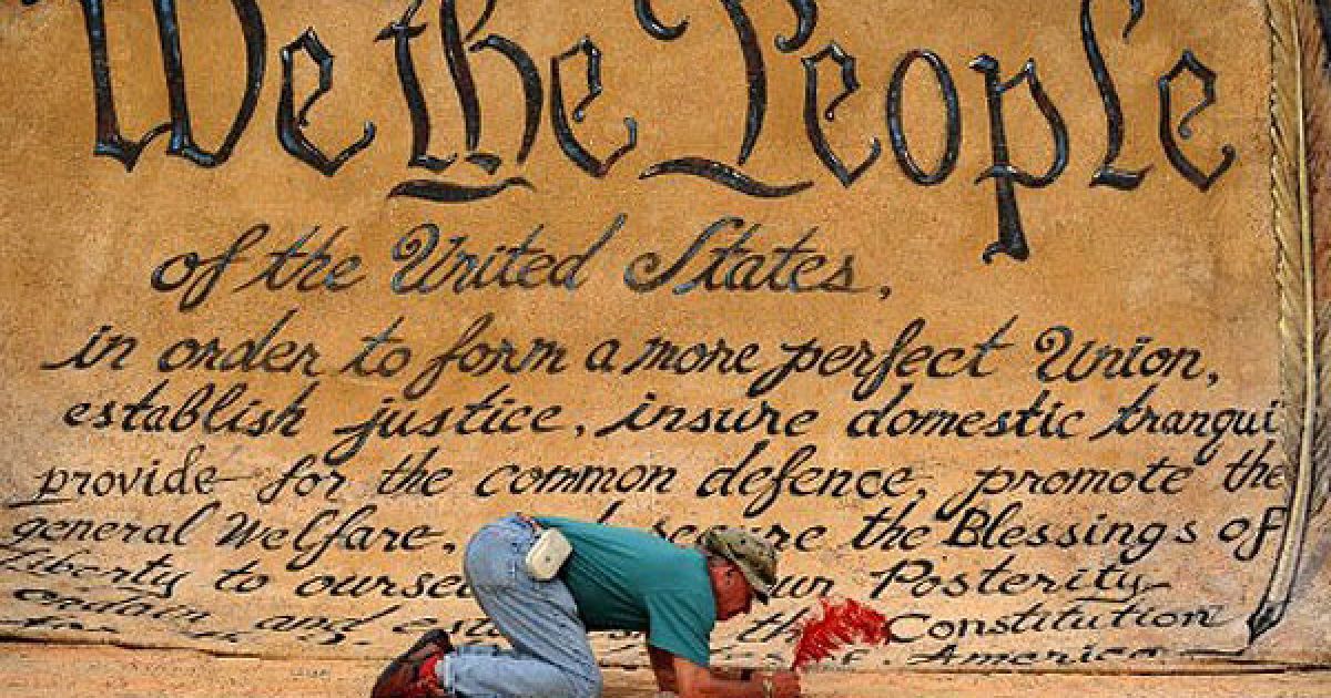 США, Вашингтон. Чоловік сидить перед величезним банером під час участі в акції протесту "Окупуй Уолл-стріт" у Вашингтоні, округ Колумбія. / © AFP