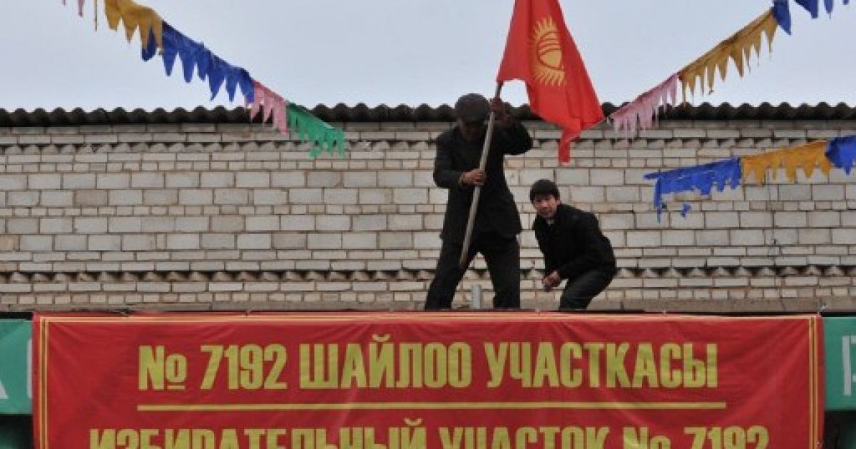 Киргизстан, Беш-Кунгей. Працівники встановлюють національний прапор Киргизії на даху місцевої виборчої дільниці в селищі Беш-Кунгей поблизу Бішкека. Країна готується до майбутніх президентських виборів, які призначені на 30 жовтня. / © AFP