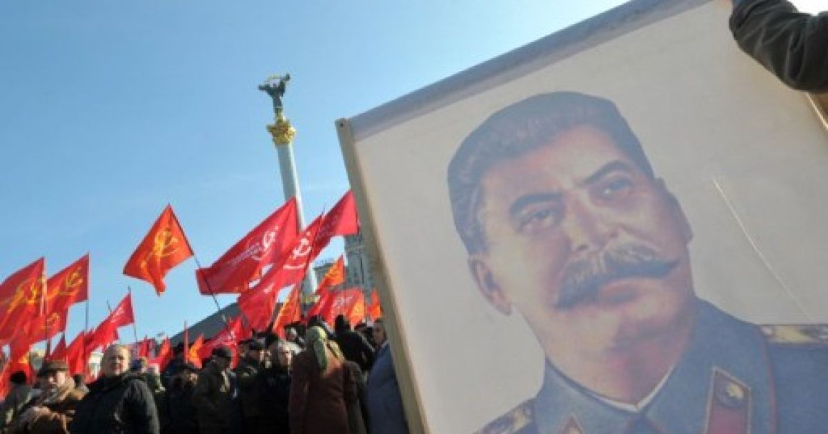 Україна, Київ. Українські комуністи з портретом колишнього радянського лідера Йосипа Сталіна беруть участь у мітингу на площі Незалежності під час святкування 94-ої річниці Жовтневої революції 1917 року, яка привела більшовиків до влади. / © AFP