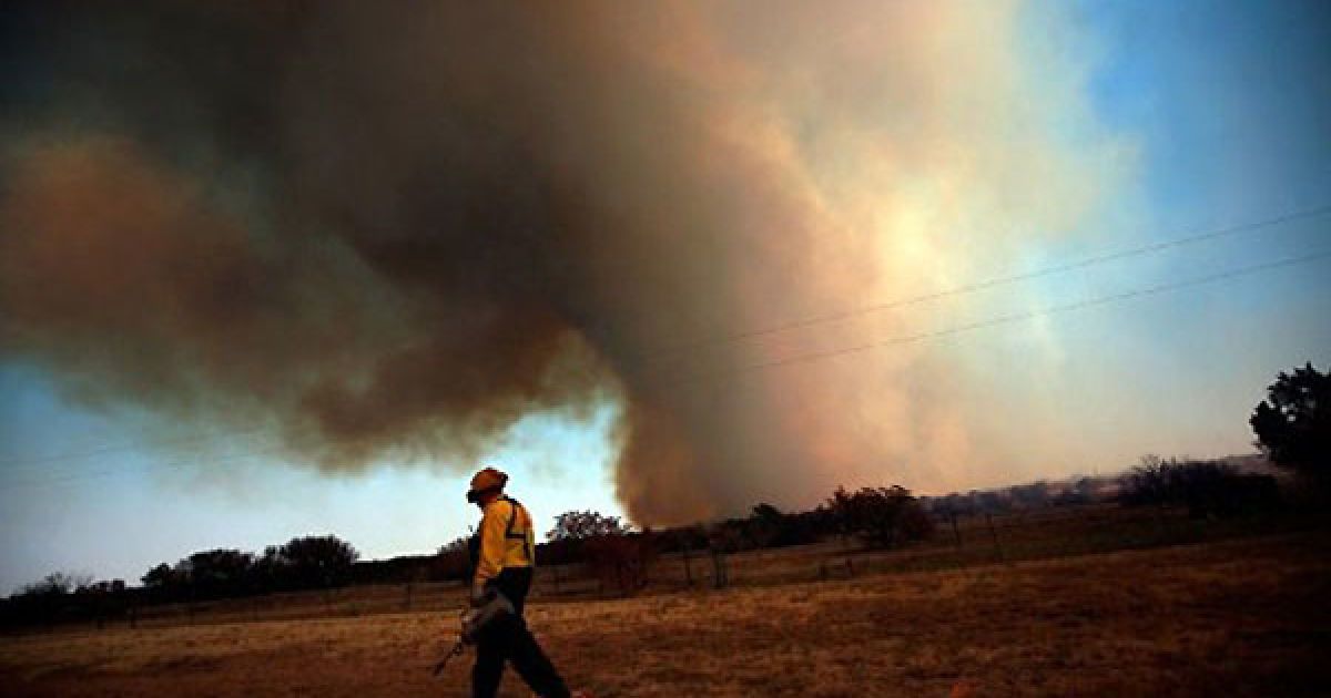 США, Графорд, штат Техас. Пожежний-волонтер бере участь у гасінні лісової пожежі в штаті Техас. Більше 45 будинків у цьому районі згоріли, доки лісові пожежі поширювалися через Техас і Оклахому. / © AFP