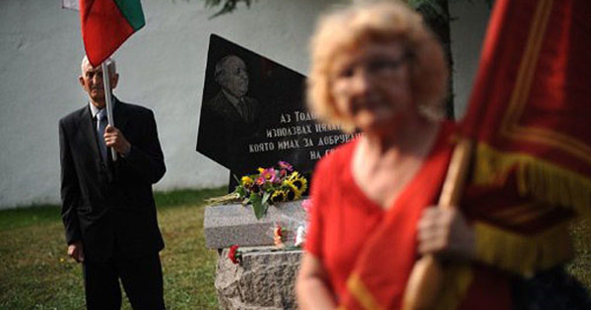 Болгарія, Правец. Люди із національними прапорами Болгарії та прапорами компартії прийшли до меморіальної дошки, щоб відзначити 100 років від дня народження комуністичного диктатора Тодора Живкова. / © AFP