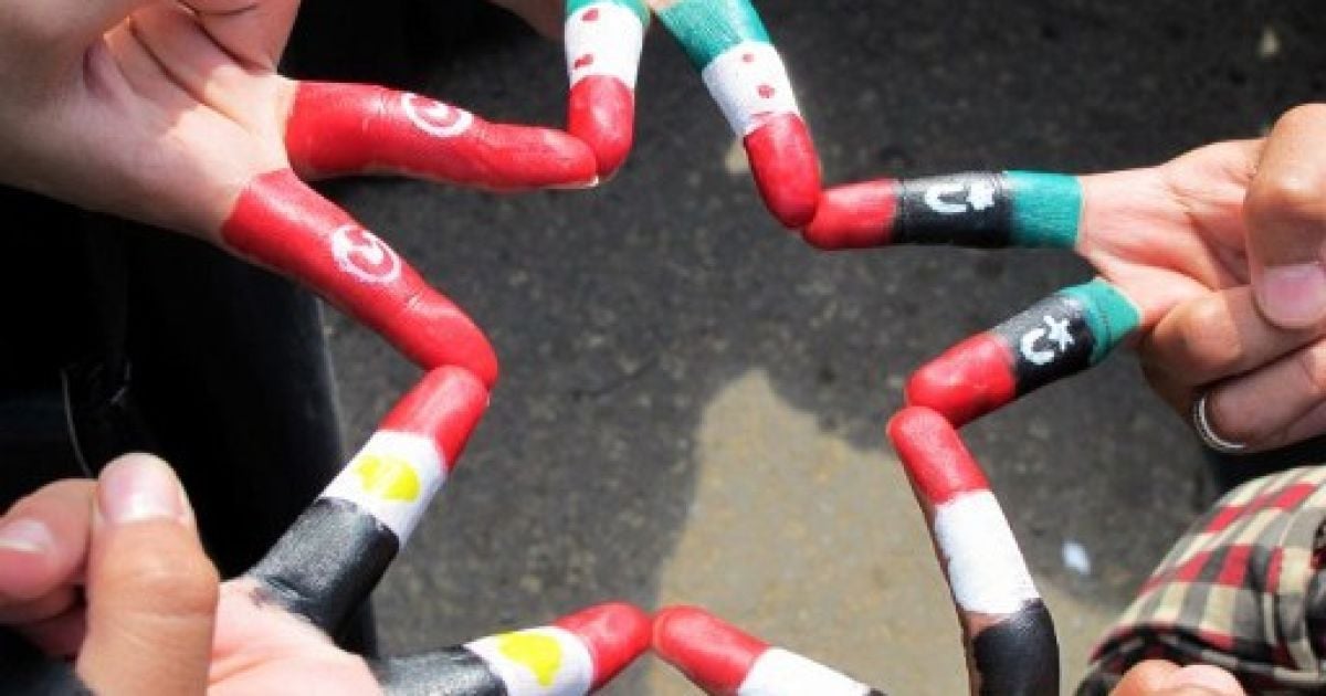 Ємен, Сана. Єменські жінки показують свої пальці, пофарбовані у кольори туніського, сирійського, лівійського, єменського і єгипетського прапорів під час масової акції протесту проти президента Алі Абдалли Салеха в Сані. / © AFP