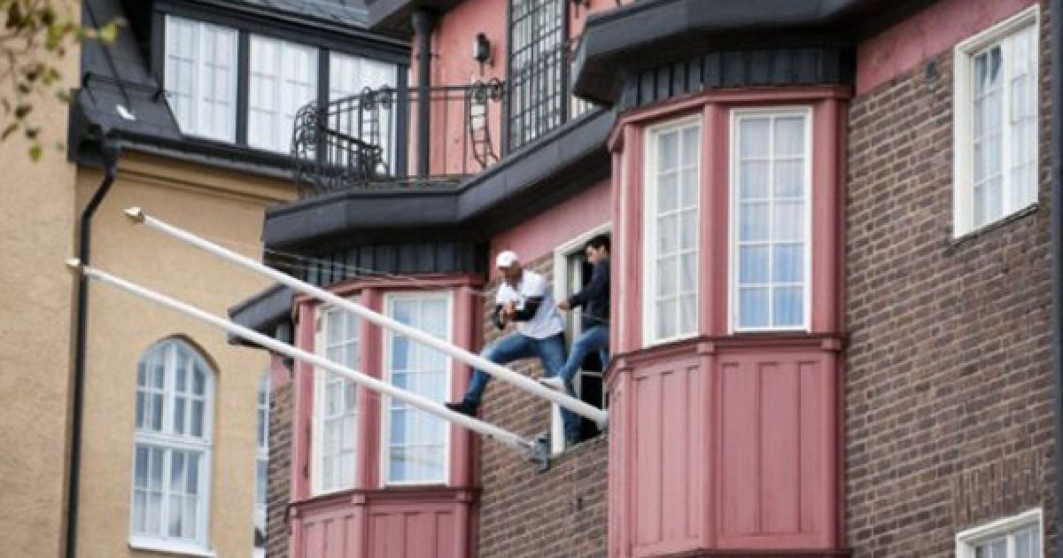 Швеція, Стокгольм. Група активістів намагається зірвати прапор з флагштоку на стіні посольства Лівії у Стокгольмі. Кілька молодих людей увірвалися до посольства та погрожували вистрибнути з вікна. Поліція вважає, що порушники були учасниками анти-лівійської демонстрації. / © AFP