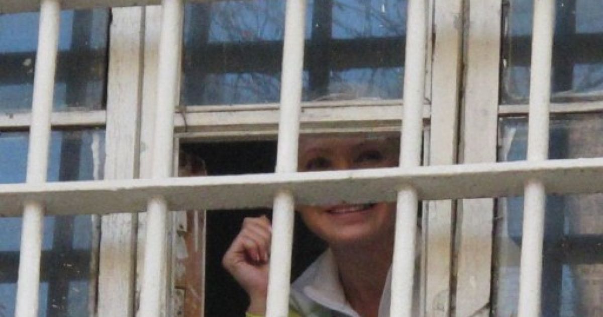 Україна, Київ. Екс-прем'єр-міністр України Юлія Тимошенко вітає своїх прихильників з-за ґрат Лук&rsquo;янівського СІЗО в Києві. Тимошенко посміхалась учасникам акції на її підтримку, які скандували "Свободу Юлії". / © AFP