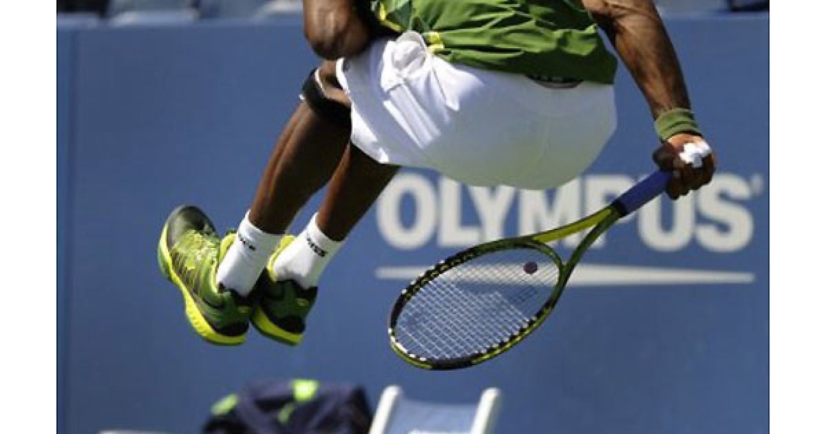 США, Нью-Йорк. Французький спортсмен Гаель Монфіс стрибає у повітря та відбиває подачу іспанця Хуана Карлоса Ферреро під час гри на турнірі US Open у Національному тенісному центрі USTA Біллі Джин Кінг в Нью-Йорку. / © AFP