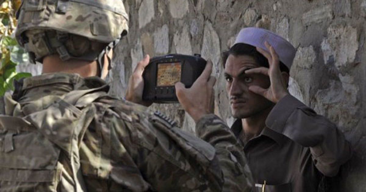 Афганістан, Турхам. Американський солдат Алекс Лоутон сканує очі афганця для внесення інформації до автоматизованої системи біометричної ідентифікації. / © AFP