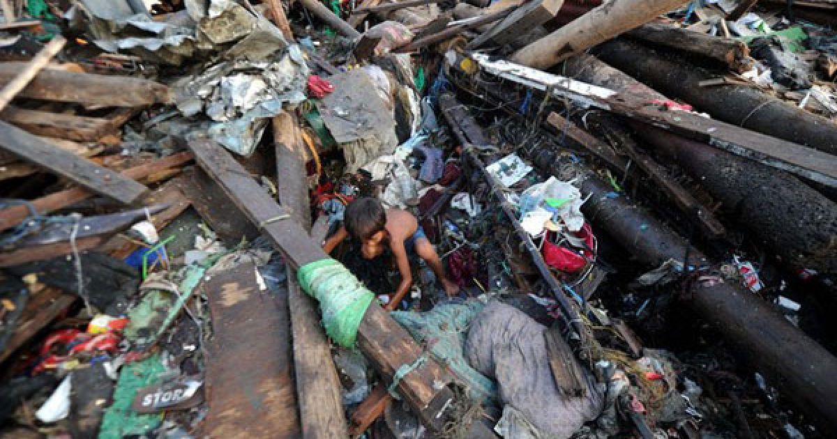 Філіппіни, Маніла. Діти розбирають завали на місці зруйнованого під час тайфуну Несат будинку в Манілі. В результаті тайфуну, загинули щонайменше 39 людей, десятки людей досі вважають зниклими безвісти. / © AFP