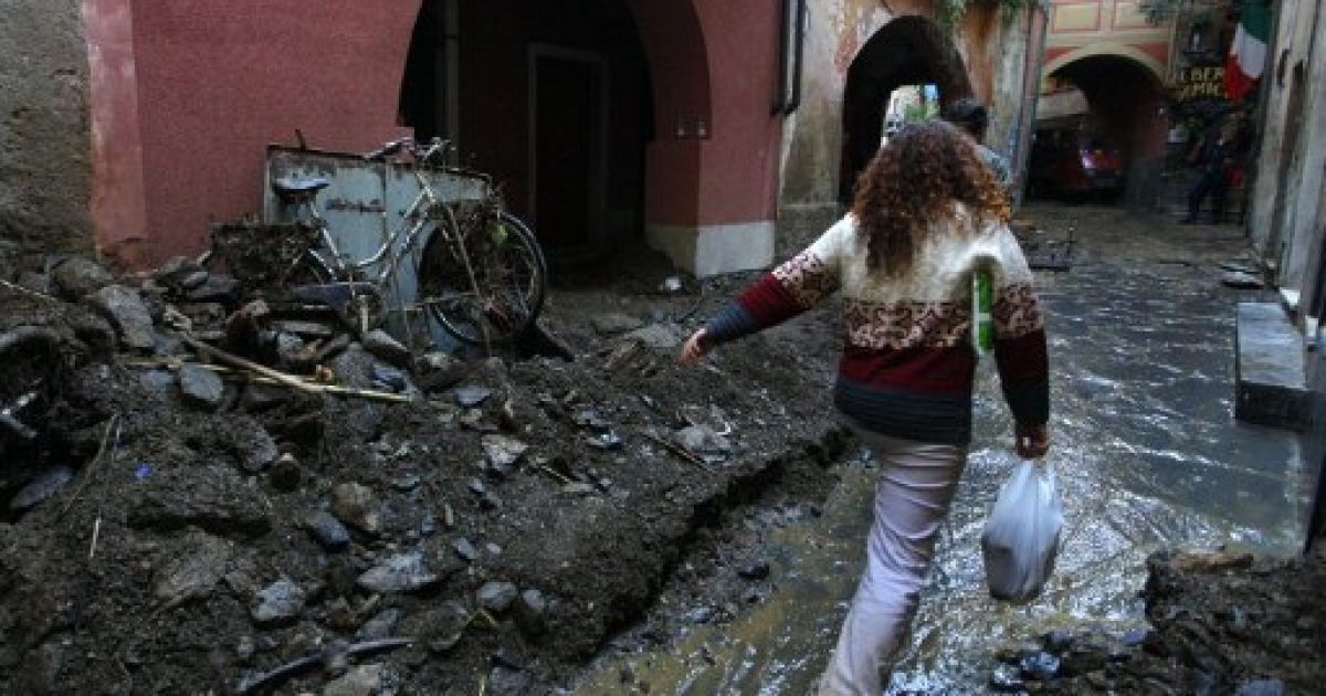Італія, Монтероссо. Місцеві мешканці пробираються крізь залиті брудом та завалені сміттям вулиці міста Монтероссо, одного з п&#039;яти населених пунктів, які постраждали від повені на півночі Італії у регіоні Спеція. В результаті повені, семеро людей загинули. / © AFP