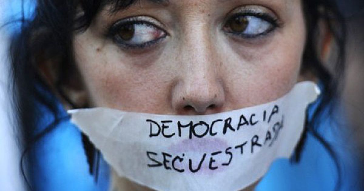 Іспанія, Мадрид. Учасниця акції протесту "обурених" зі стрічкою на роті із написом "Викрадена демократія" бере участь у демонстрації проти планів внести правила збалансованого бюджету до конституції в Мадриді. / © AFP