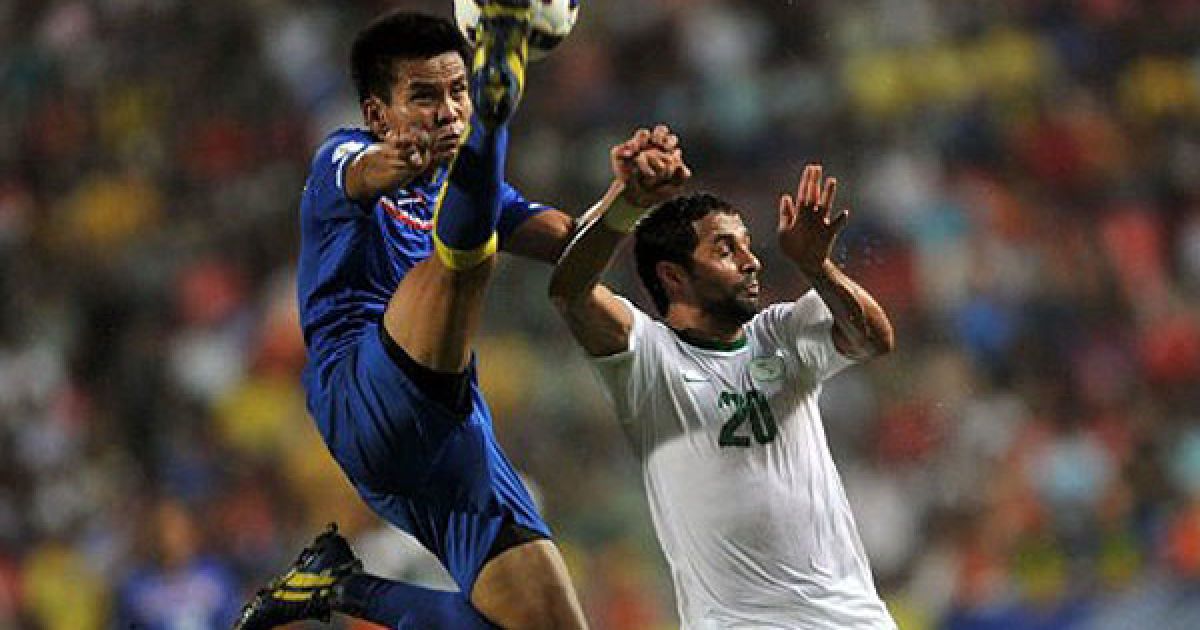 Таїланд, Бангкок. Гравець збірної Таїланду Чонлатіт Янтакам бореться за м&#039;яч із гравцем збірної Саудівської Аравії Яссером Аль Кахтані під час відбіркового матчу на Чемпіонаті світу 2014. / © AFP