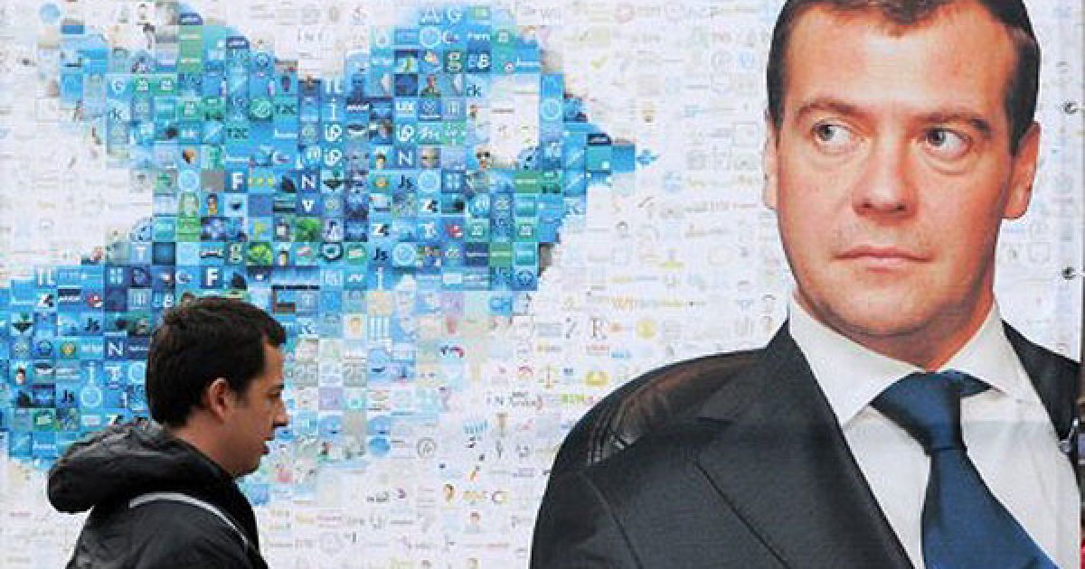 Росія, Москва. Людина проходить повз портрет президента Росії Дмитра Мєдвєдєва, встановлений активістами прокремлівського молодіжного руху "Наші" на Пушкінській площі в Москві. Молодіжний рух привітав російського лідера з 46-річчям. / © AFP