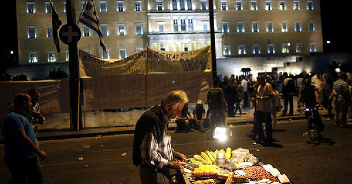 Греція, Афіни. Вуличний торговець продає варену кукурудзу таксистам, які влаштували акцію протесту перед будівлею грецького парламенту. Таксисти провели в Афінах черговий 48-годинний страйк. / © AFP