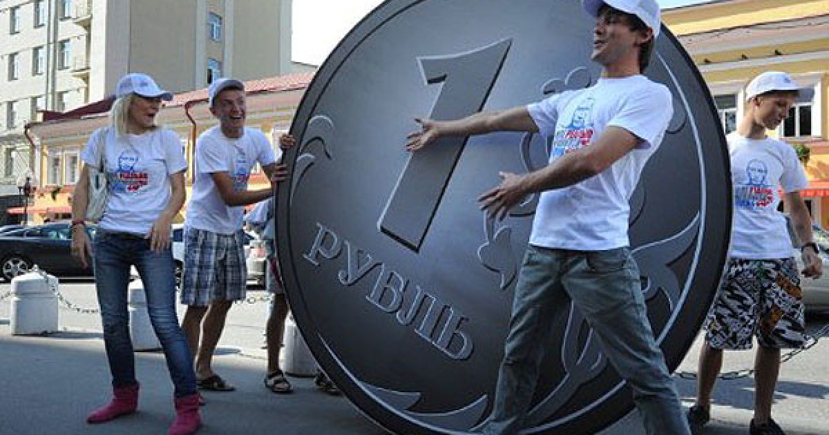 Росія, Москва. Члени групи з соціальної мережі "Мені реально подобається Путін" виступають поруч із двометровою монетою російського рубля в Москві під час акції на підтримку валюти Росії. / © AFP