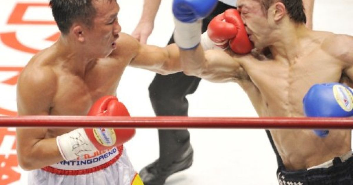 Японія, Токіо. Тайський чемпіон Порнсаван Порпрмук влучним ударом збиває претендента на титул, японця Акіру Яєгаші під час двобою за пояс WBA у найлегшій вазі в Токіо. Японський боксер Яєгаші виграв матч у 10-му раунді та відібрав пояс у Порпрмука. / © AFP