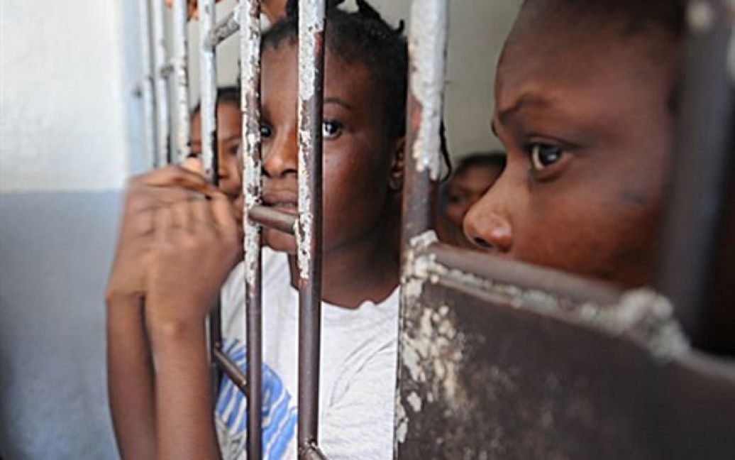 28.06. Жінки визирають зі своєї камери у тюрмі Порт-о-Пренса. В&rsquo;язниці Гаїті переповнені людьми, яким не винесено вироку, через зупинку у судочинстві, яка викликана страшним землетрусом 12 січня. / © AFP