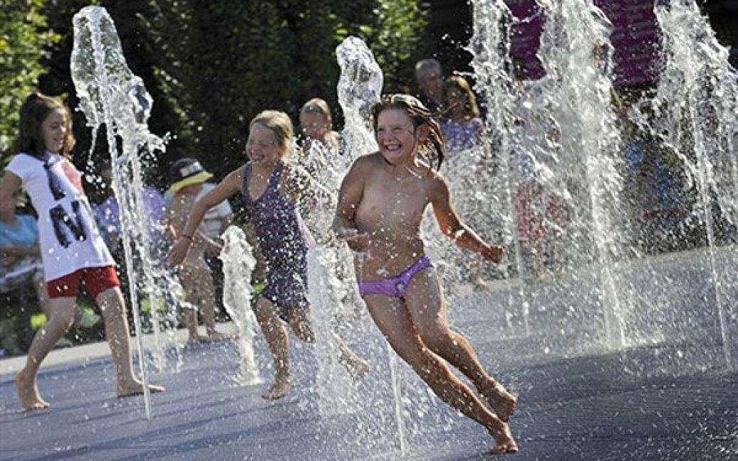 Франція, Ільріх-Граффенстаден. Діти грають у фонтані, щоб трохи освіжитися, у місті на сході Франції. У Європі утримується спекотна суха погода. / © AFP