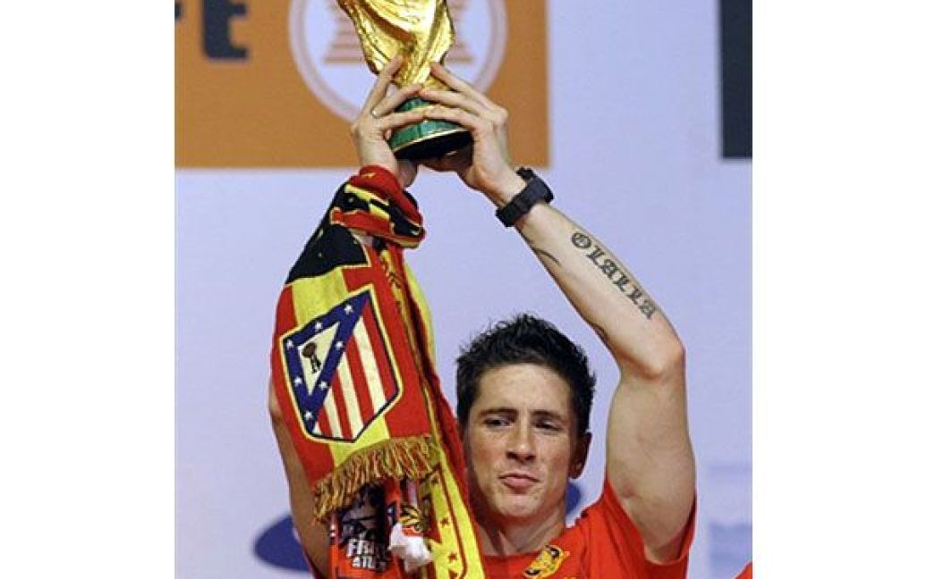 Нападаючий збірної Іспанії Фернандо Торрес тримає Кубок світу з футболу. / © AFP