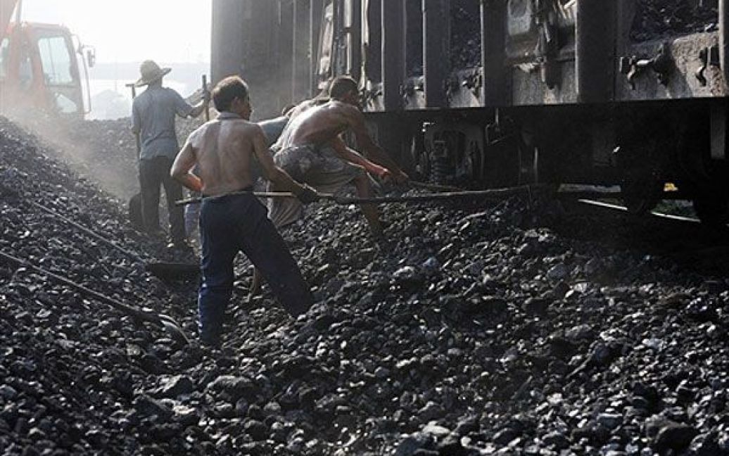 Китай, Хефей. Китайські шахтарі вивантажують вугілля з потягу у Хефеї, провінція Аньхой. Китай за рахунок вугілля задовольняє близько 70 відсотків своїх потреб у електроенергії. / © AFP