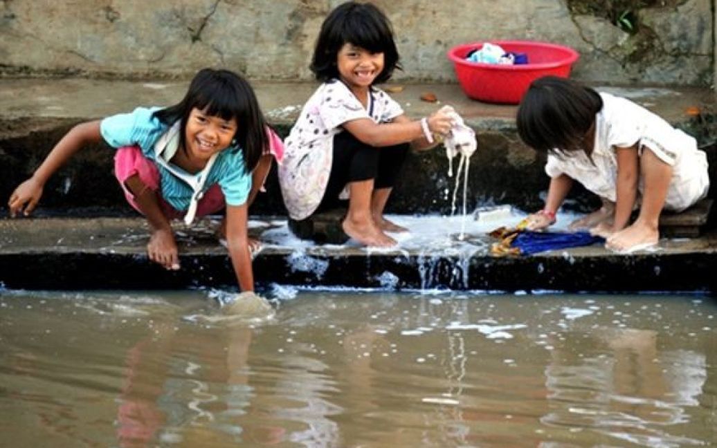 Троє дівчат перуть одяг у ріці на окраїні Джакарти. Згідно із останнім переписом населення, в Індонезії проживає 237 мільйонів людей. Індонезія стала четвертою найбільш населеною країною світу. Перші три сходинки посіли Китай, Індія та США. / © AFP