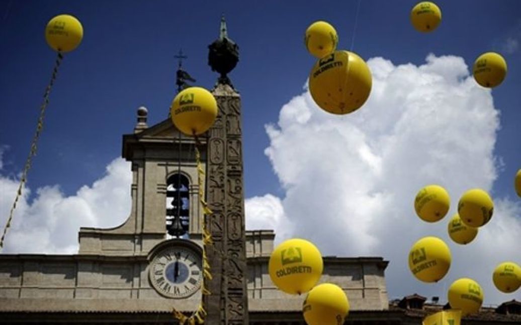 Італійські фермери запустили у повітряні кульки, які символізують обіцянки уряду, під час акції протесту біля парламенту Італії. Фермери вимагали виплати штрафів, які були накладені на них протягом останніх 20 років. / © AFP
