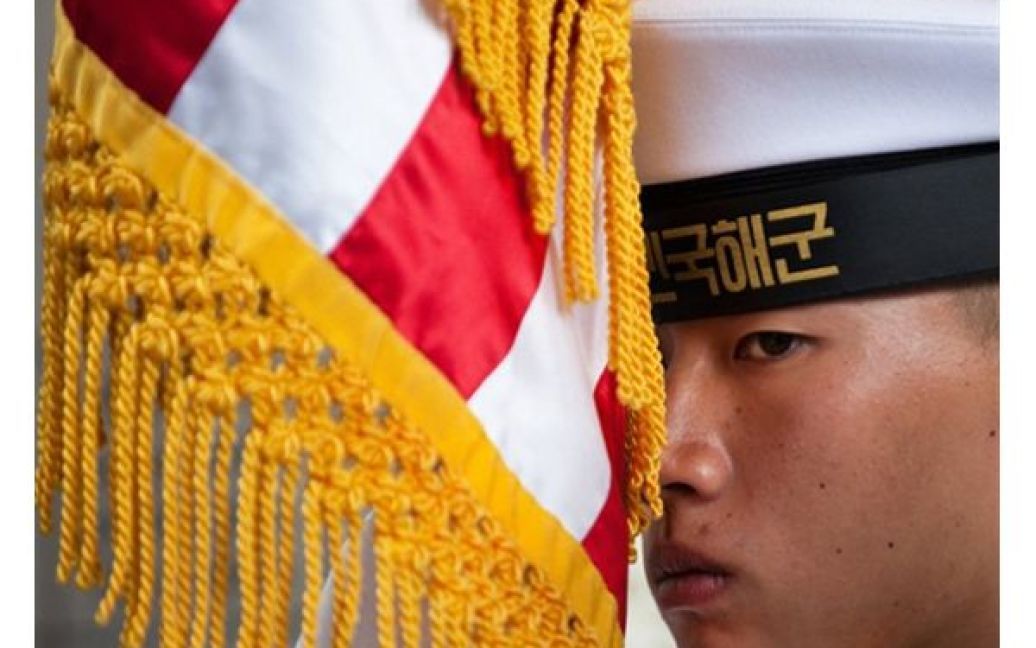Солдат корейської почесної варти тримає прапор США під час зустрічі держаного секретаря США Гілларі Клінтон у Сеулі. США накладе додаткові санкції на КНДР за затоплення південнокорейського ракетного катера. / © AFP