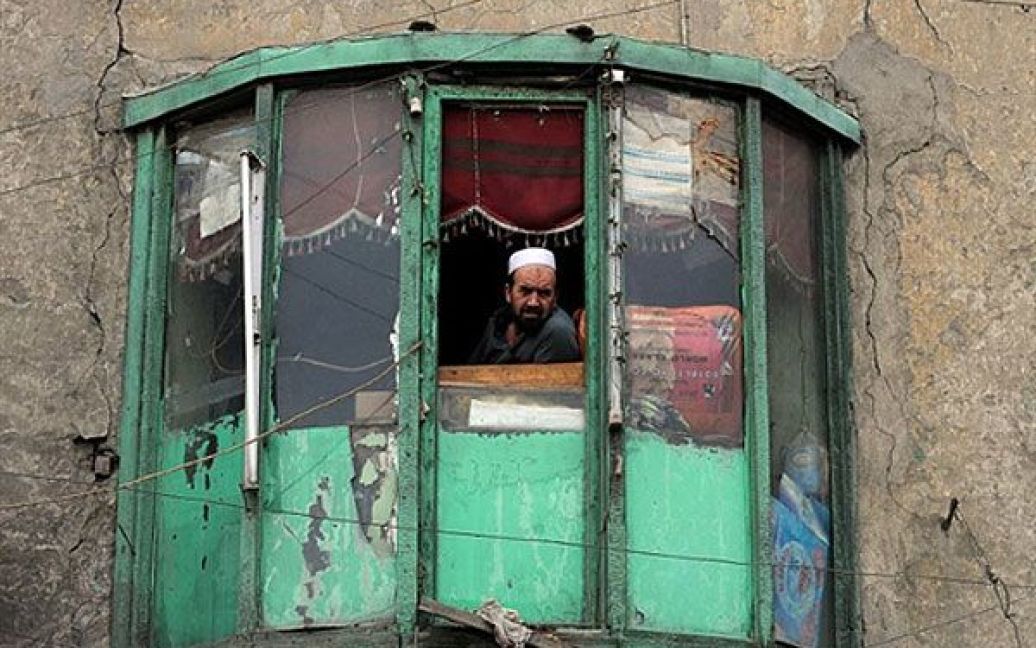Афганістан, Кабул. Афганський власник ресторану виглядає зі свого балкону на жвавий ринок у Кабулі. Жертви серед цивільного населення Афганістану від зброї іноземних військ викликають вельми неоднозначну реакцію протягом усіх дев&#039;яти років афганської війни. Скорочення кількості таких випадків розглядається як основний момент для стратегії США по боротьбі з повстанцями, спрямованої на повне припинення конфлікту. / © AFP