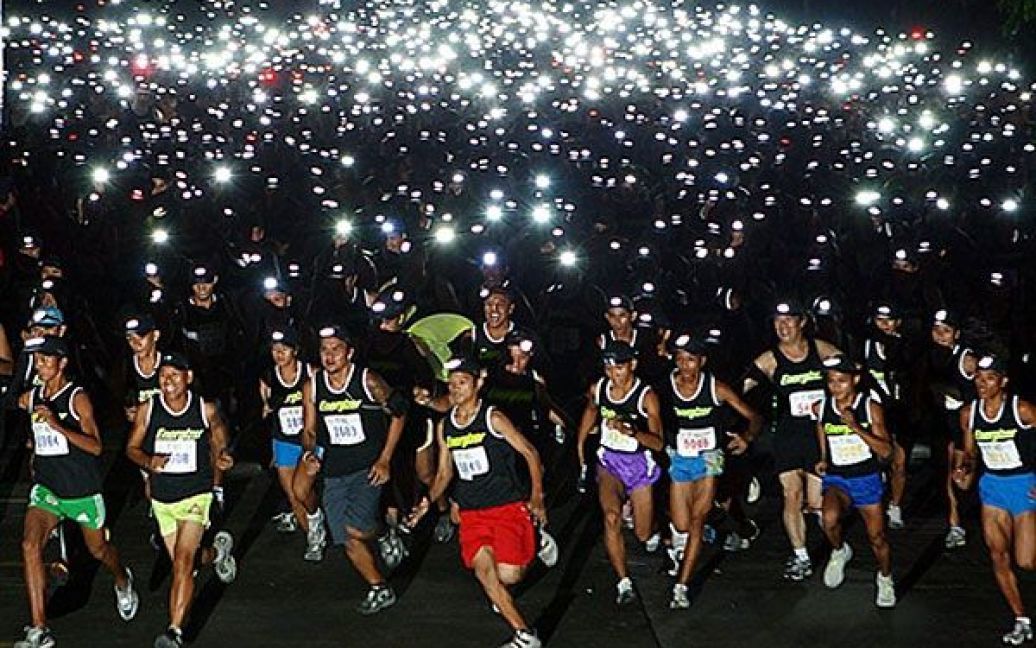 Філіппіни, Себу. Тисячі бігунів з ліхтариками беруть участь у нічному забігу "Energizer night race". Забіг відбувся у рамках благодійної акції "Біжи заради мети" на користь глухих дітей у провінції Себу. / © AFP