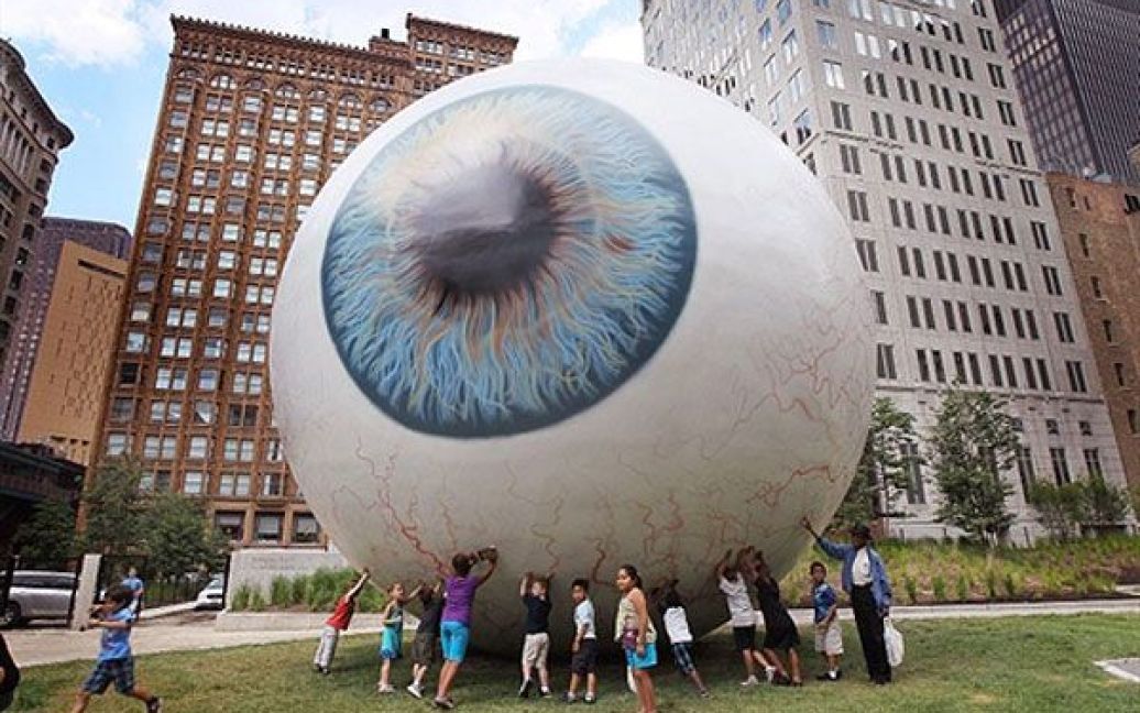 США, Чикаго. Відвідувачі роздивляються гігантське 30-футове очне яблуко, яке створив скульптор Тоні Тассет. Скульптуру виставили у Прітцкер-парку у Чикаго, штат Іллінойс, де її можна буде побачити до 31 жовтня. / © AFP