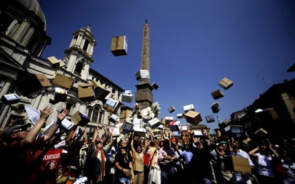 Римляни кидають у повітря коробки, у яких лежать 4 тисячі підписів проти приватизації фонтану на площі П&lsquo;яцца Навона. / © AFP