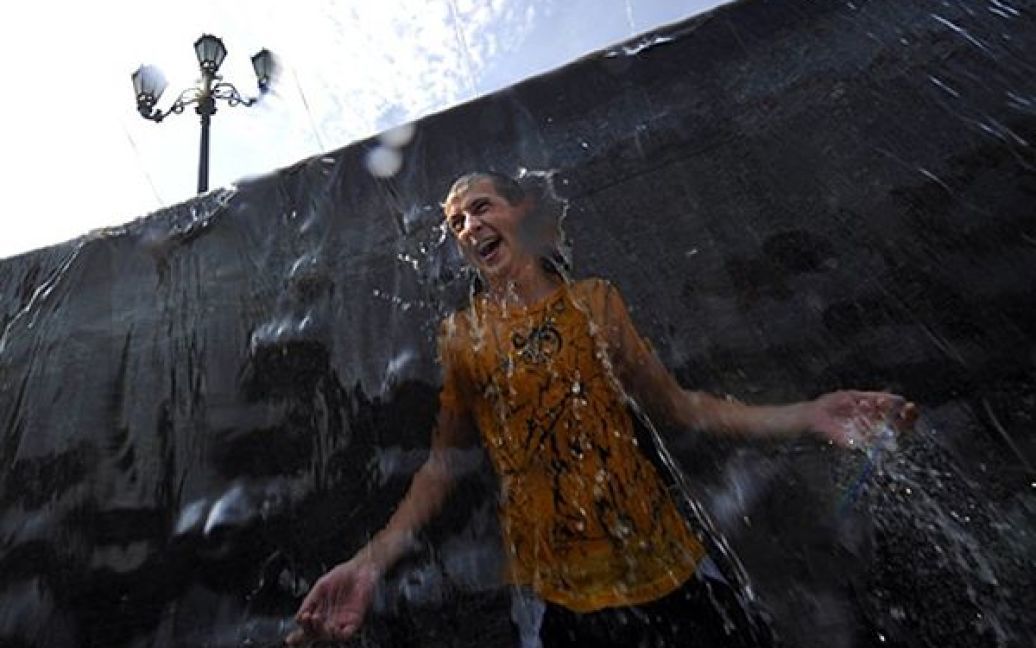 Хлопець купається у фонтані у Москві. Сьогодні у російській столиці зафіксували температуру 37,2 градуса, що є рекордом за всю історію метеоспостереження. / © AFP