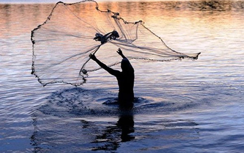 Шрі-Ланка, Баттіколоа. Шрі-ланкійський рибалка закидує свою сіть у море поблизу міста Баттіколоа. Рибальство у регіоні стало відроджуватись після того, як уряд країни завершив 37-річну війну з "тамільськими тиграми". / © AFP