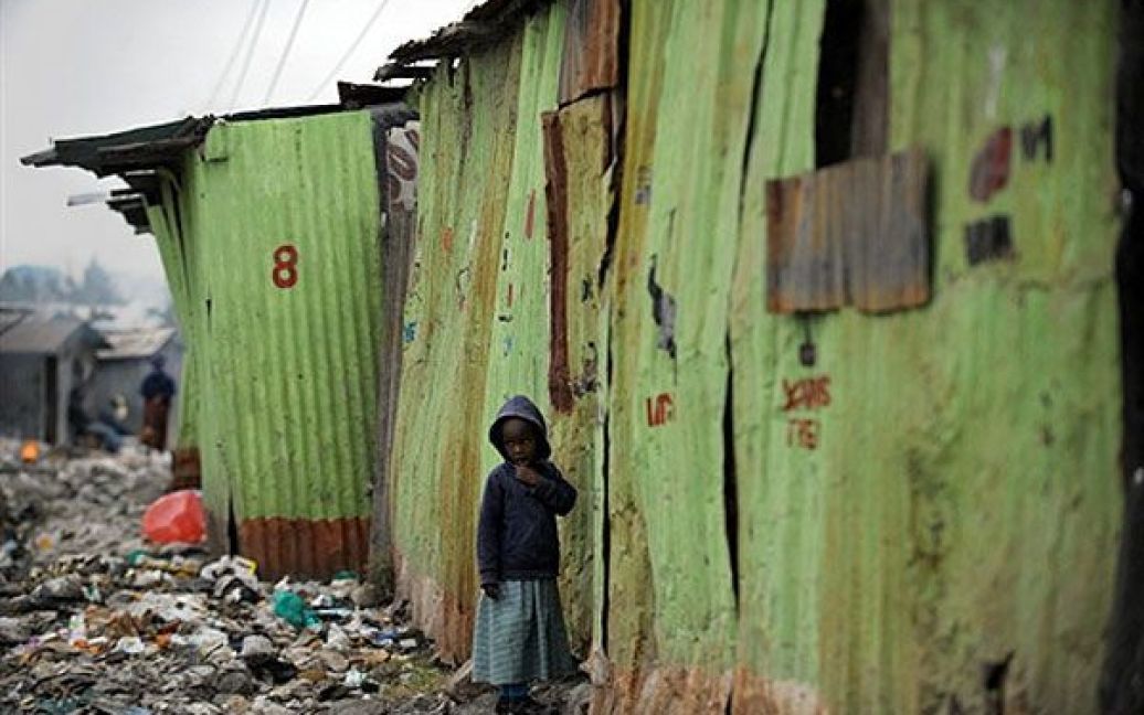 Кенія, Найробі. Дівчинка стоїть поруч зі шкільним класом у нетрях Мукуру-ква-Ндженга. Жінки і дівчата у нетрях Найробі живуть під постійною загрозою сексуального насильства, в результаті чого вони надто налякані, щоб часто залишати свої будинки та користуватись комунальними туалетами і ванними кімнатами. Організація "Міжнародна амністія" у доповіді "Небезпека і зневага: досвід жінок у нетрях Найробі, Кенія" детально описала, як нездатність уряду перетворити нетрі у нормальні міські райони та відсутність фінансування призвели до катастрофічного зниження рівня гігієни і санітарії у місті. / © AFP