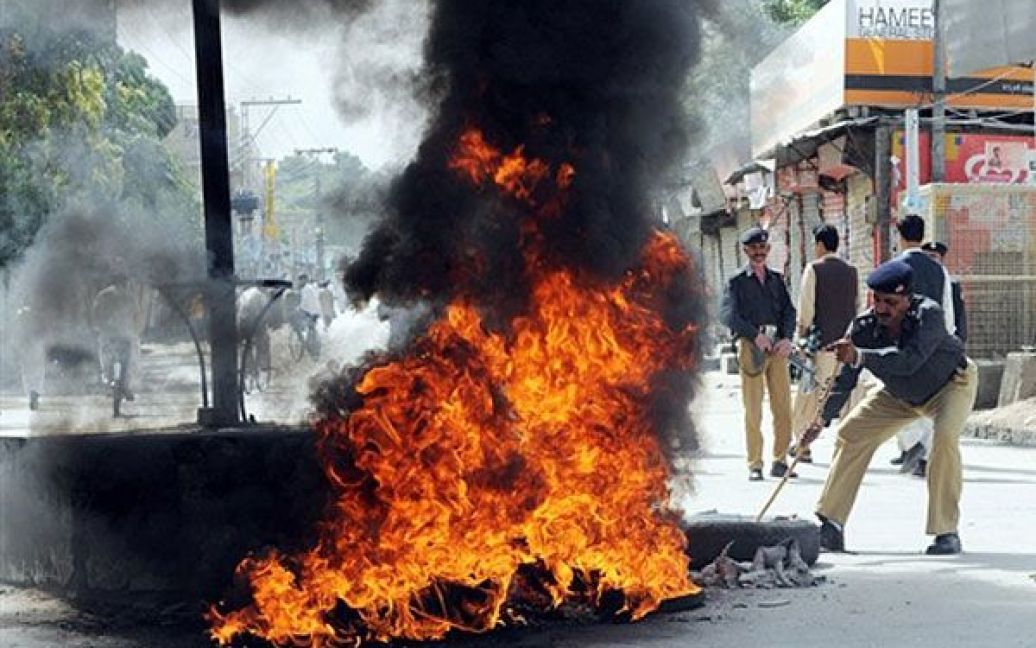Пакистан, Кветте. Пакистанський поліцейський намагається прибрати шини, підпалені під час акції протесту, яку влаштували активісти національної партії Белуджістана. Таким чином, вони демонстрували свій протест проти вбивства політичного лідера Хабіба Джаліба, яке сталося у місті Кветта 14 липня 2010 року. Бойовики вбили націоналістичного лідера повстанців, коли він вийшов зі свого будинку на околиці Кветти. Джаліб був генеральним секретарем опозиційної фракції національної партії Белуджістана, яка виступає за автономію південно-західної провінції і добивається самовизначення мирним шляхом. / © AFP