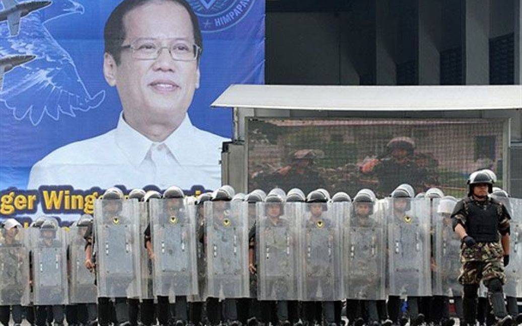 Філіппіни, Маніла. Філіппінські солдати ВПС з підрозділу "по боротьбі із заворушеннями" проходять маршем перед гігантським плакатом із зображенням президента Беніньо Акіно. У Манілі відбулись урочистості з нагоди 63-ої річниці військово-повітряних сил Філіппін. Президент Акіно пообіцяв підтримку збройним силам у спробі придушити маоїстських повстанців і ісламістський заколот, який "кипить на повільному вогні" у країні протягом десятиліть. / © AFP