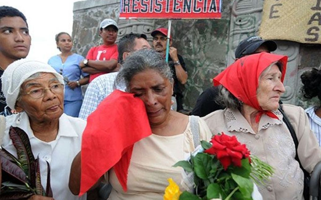Гондурас, Тегусігальпа. Сільвія Кастільо (в центрі), мати Айзіса Обеда Мурільо, вшановує його пам&rsquo;ять на місці, де її син був убитий військовими рік тому в околицях Тегусігальпи. Айзіс Мурільо був убитий під час мітингу-зустрічі поваленого президента Гондурасу Мануеля Селайї, коли Селайя намагався повернутись до Гондурасу на венесуельському літаку. / © AFP