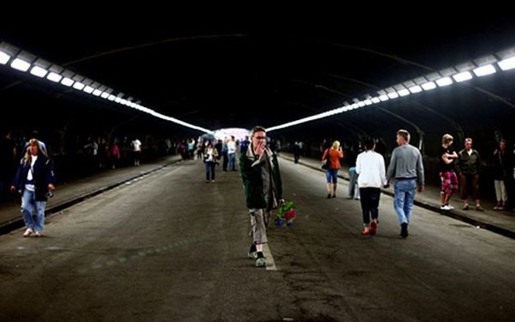 Люди приносять квіти до тунелю, де у тисняві загинули 19 людей. / © AFP