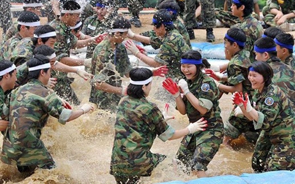 Республіка Корея, Пучхон. Південно-корейські добровольці борються у каламутній воді під час тренування у таборі для цивільних осіб на військовій базі спецпідрозділів у Пучхоні. Тренувальний табір є частиною літньої програми, організованої армією для 1245 цивільних жителів, включаючи 364 жінок, які добровільно погодились отримати досвід жорсткої військової підготовки. / © AFP