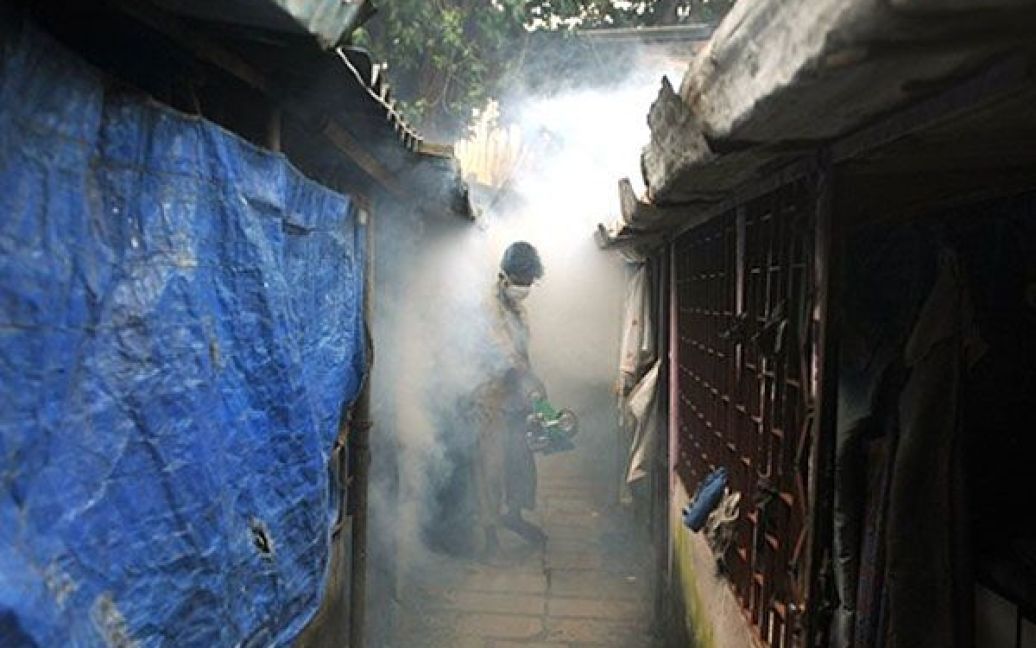 Індія, Мумбаї. Муніципальний службовець обкурює житловий район дезінфікуючим пристроєм для боротьби з малярією. Муніципальна корпорація Brihanmumbai (BMC) знімає для мешканців Мумбаї короткометражний фільм про боротьбу з малярією, яка вже забрала 41 життя, починаючи з січня. / © AFP