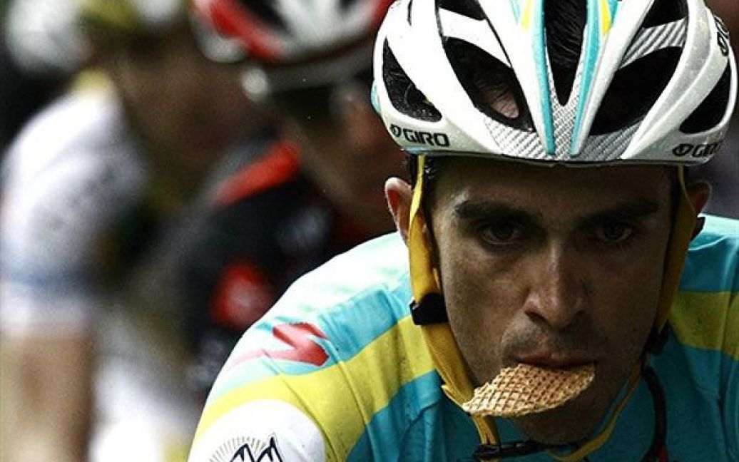 Бельгія, Спа. Іспанський велогонщик Альберто Контадор їсть печиво, бо часу на нормальний обід в нього немає, - він їде у групі лідерів під час одного з етапів велогонки Тур де Франс. / © AFP