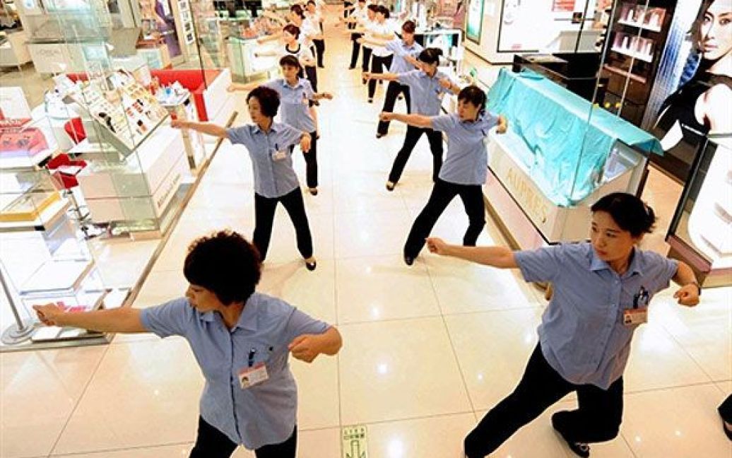 Китай, Пекін. Китайські працівниці роблять вранішні вправи перед відкриттям торгового центру в Пекіні. Активне сальдо торговельного балансу Китаю у липні виросло до 28,7 млрд. доларів, через рекордне зростання експорту. / © AFP