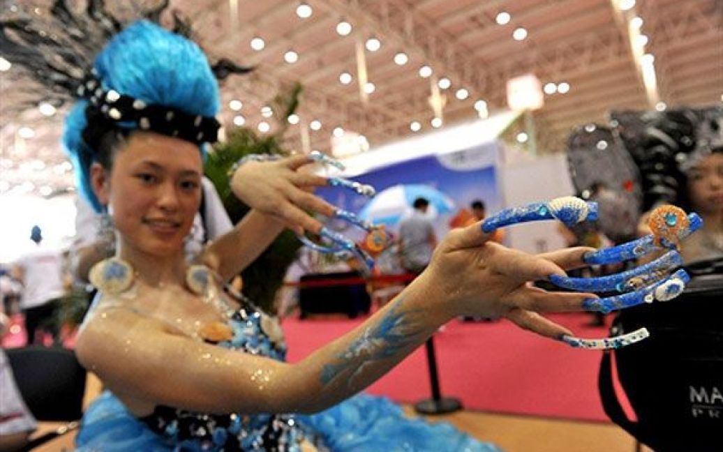 Пекін, Китай. Дівчина демонструє свою зачіску та манікюр на виставці індустрії краси, яка почалась у Пекіні. Китай стверджує, що його економіка у 2009 році зросла на 9,1 відсотка, отже, розрив між другою у світі економікою Японії та економікою Китаю скоротився. / © AFP