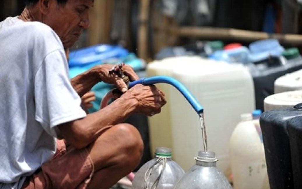 Чоловік набирає воду з джерела у нетрях Маніли. Більшість районів Маніли страждають від нестачі питної води, яка викликана посушливим літом. / © AFP